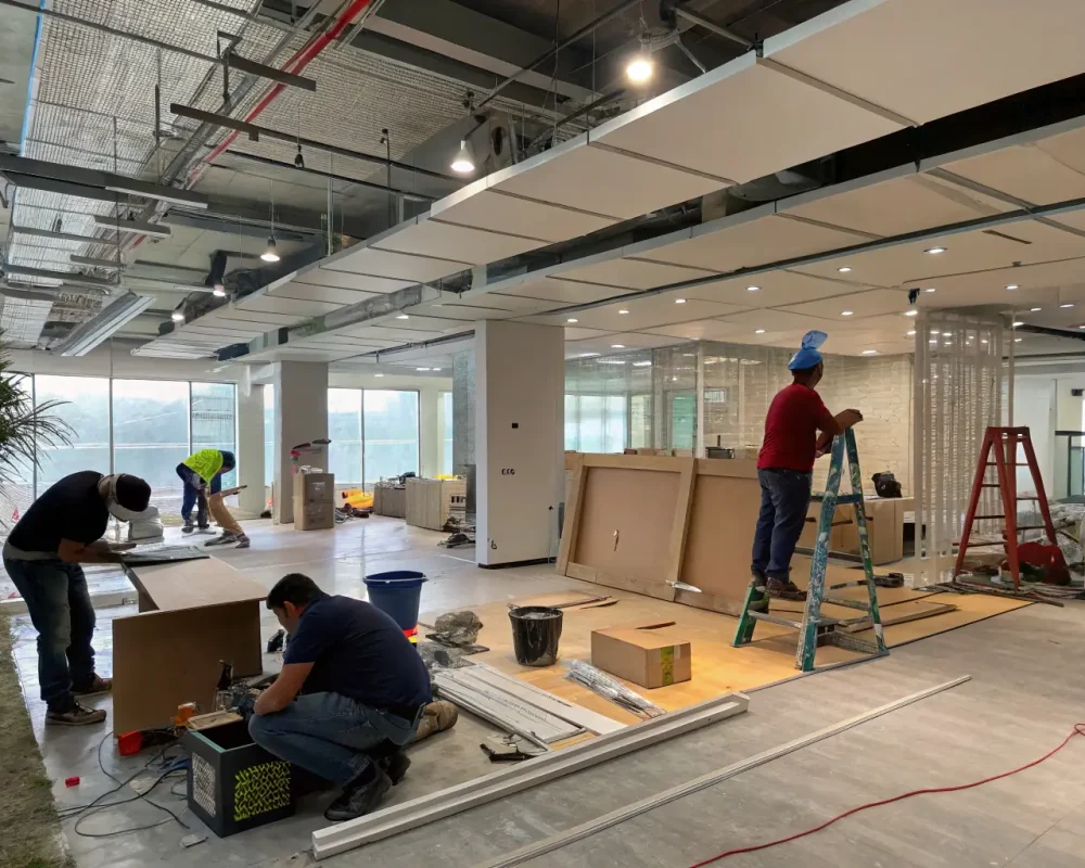 A commercial space undergoing tenant improvements, with workers installing new flooring and painting walls, illustrating Solid Ground Construction's commercial services.